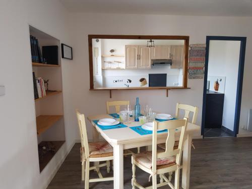 einen Esstisch und Stühle in einem Zimmer in der Unterkunft 60m2, 2 chambres proche Hérault & plages in Agde