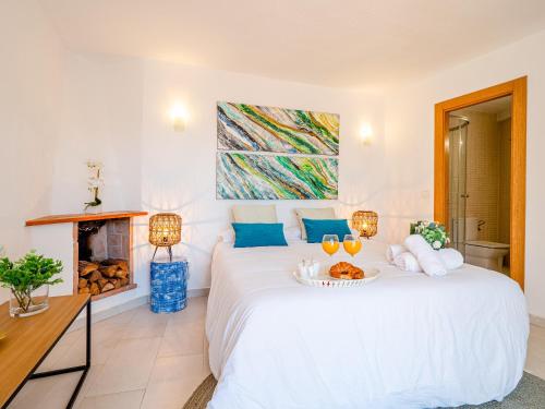 a bedroom with a large white bed and a fireplace at SEAFRONT WITH TERRACE in Málaga