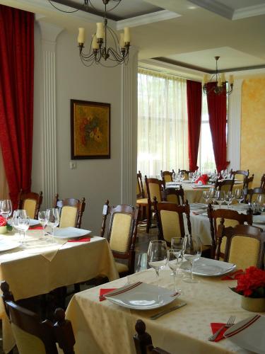 a dining room with tables and chairs with wine glasses at Casa Domneasca in Curtea de Argeş