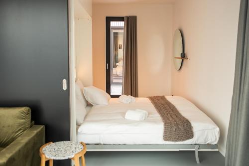 a small bedroom with a bed and a mirror at CREATIVE VALLEY NEST – Luxury Rooftop Apartments in Utrecht