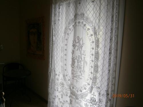 a white curtain on a window in a room at The Magic Mountain in Tsapournia