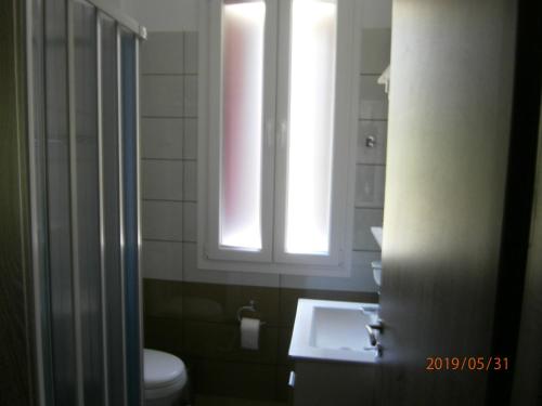 a bathroom with a toilet and a sink and a window at The Magic Mountain in Tsapournia
