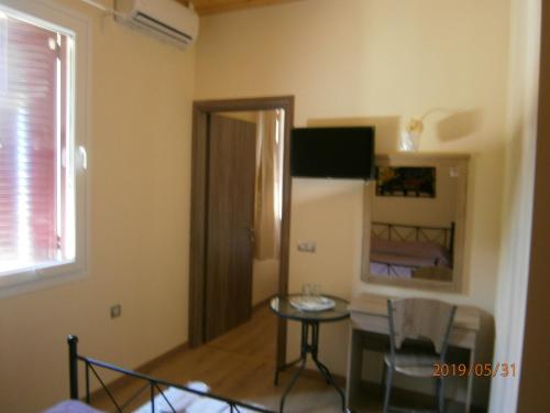 a small room with a table and a bed at The Magic Mountain in Tsapournia