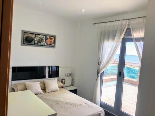 a bedroom with a bed and a view of the ocean at APARTAMENTO JMHR 5 in Benajarafe