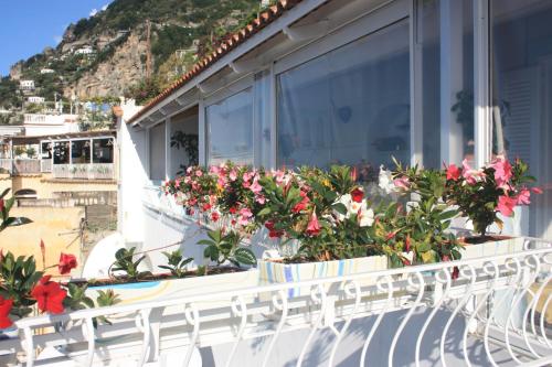 a balcony with flowers in pots on a building at Palazzo Talamo in Positano