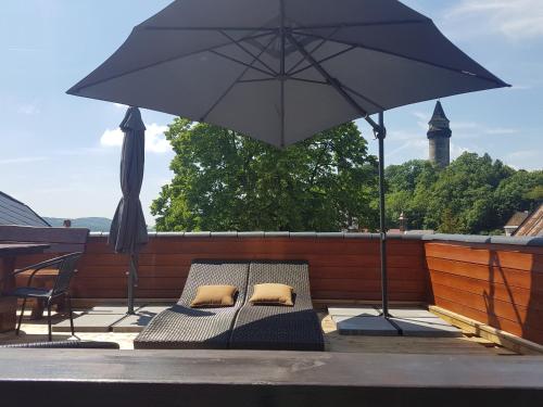 a patio with an umbrella and two beds on a deck at Kopec 67 in Štramberk