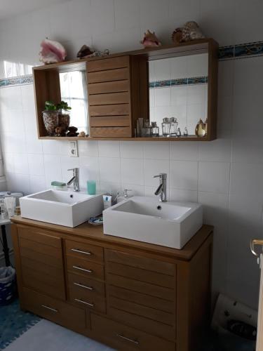 - une salle de bains avec deux lavabos sur un comptoir en bois dans l'établissement Chambre dans villa, à Gouesnou