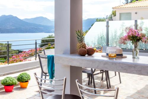 a table and chairs on a balcony with a view at Thealos Village aparthotel Lefkada in Lygia