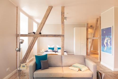 ein Wohnzimmer mit einem Sofa vor einem Bett in der Unterkunft OSTKÜSTE - Villa Albatros Design Apartments in Ahlbeck