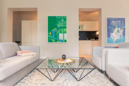 a living room with two couches and a glass table at OSTKÜSTE - Villa Albatros Design Apartments in Ahlbeck