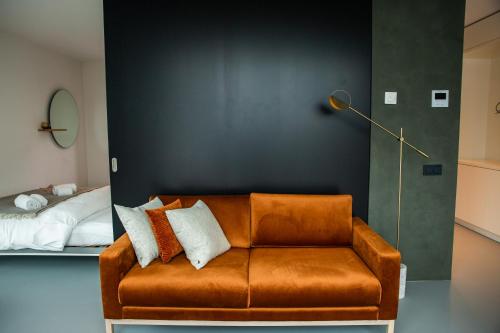 a brown leather couch in a room with a bed at CREATIVE VALLEY NEST – Luxury Rooftop Apartments in Utrecht