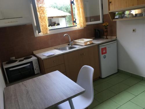 a kitchen with a table and a sink and a refrigerator at Villa Panorea in Moraitika