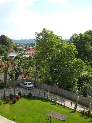 a park with a bench and a fence and a car at Casa Domneasca in Curtea de Argeş