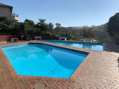 a large swimming pool with blue water at Umdloti Holiday Resort Apartments in Umdloti