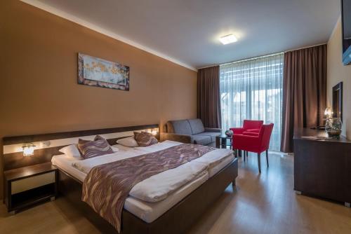 Pokój hotelowy z łóżkiem i czerwonym krzesłem w obiekcie Apartmán Bešeňová w Beszeniowej