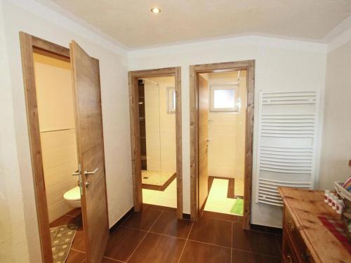 a bathroom with two doors and a toilet at Haus Helene Prantl in Längenfeld