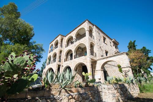 un antiguo edificio de piedra en la parte superior de una pared de piedra en Stone Palace Hotel Free Shuttle From and to Athen's Airport en Spáta