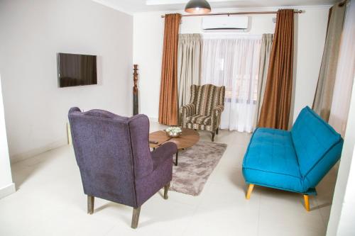 a living room with two chairs and a blue chair at MC Apartments in Lusaka