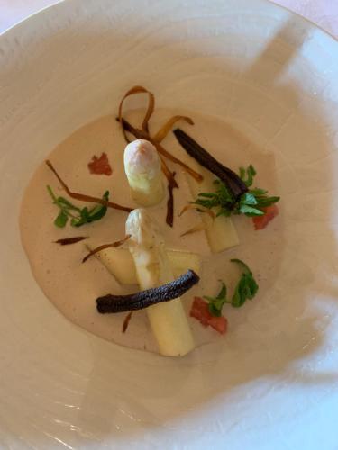 a white plate with a dish of soup with vegetables at Le Tillau in Les Verrières-de-Joux