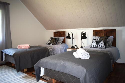a bedroom with two beds and a house on top of them at Countryside Villa Skogsbacka in Tammisaari