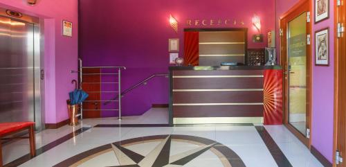 a dressing room with purple walls and a counter at Vinci Hotel Airport in Modlniczka