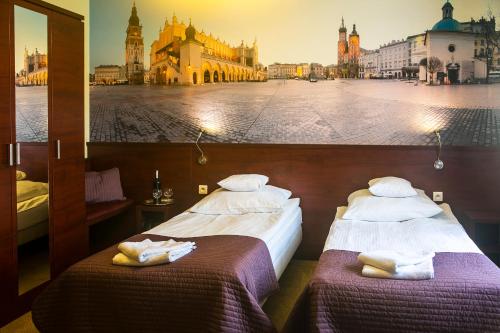 two beds in a room with a view of a city at Vinci Hotel Airport in Modlniczka