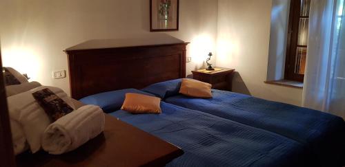 a bedroom with a blue bed with pillows on it at Poggio Al Palio in San Lorenzo a Merse
