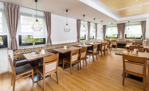 a restaurant with tables and chairs and windows at Hotel Schwan in Pottenstein