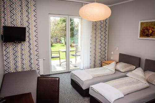 a room with two beds and a tv and a window at BeskidPark in Bielsko-Biała