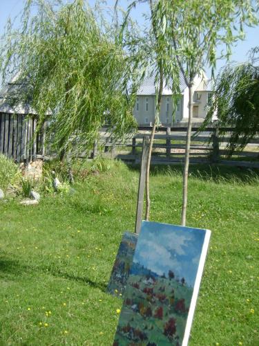 a painting sitting in the grass next to a tree at Pensiunea Popasul Iancului in Mărişel