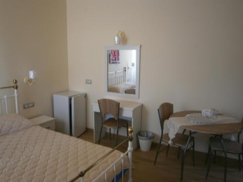 a bedroom with a bed and a table and a mirror at The Magic Mountain in Tsapournia