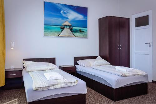 twee bedden in een kamer met een foto aan de muur bij BeskidPark in Bielsko-Biala