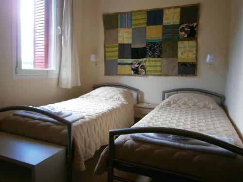 a bedroom with two beds and a quilt on the wall at The Magic Mountain in Tsapournia