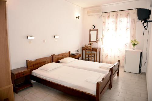 a bedroom with two beds and a window at Anthemis Hotel in Agios Kirykos