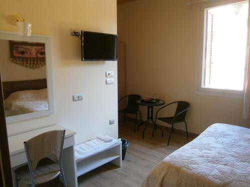 a bedroom with a bed and a mirror and a table at The Magic Mountain in Tsapournia