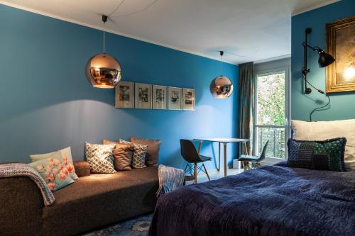 Studio Apartment in Dresden-Neustadt في درسدن: غرفة نوم بجدران زرقاء وأريكة وطاولة