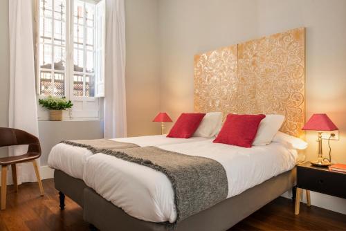 sypialnia z dużym łóżkiem z czerwonymi poduszkami w obiekcie Imperial Luxury Apartment w Sewilli