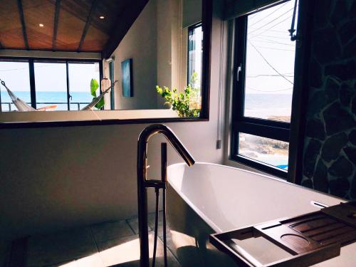 a bathroom with a bath tub and a window at Casa Ostia in Hengchun