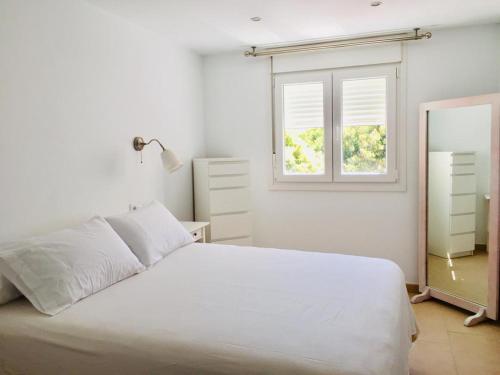 biała sypialnia z łóżkiem i oknem w obiekcie Casa Luz w mieście Tarifa
