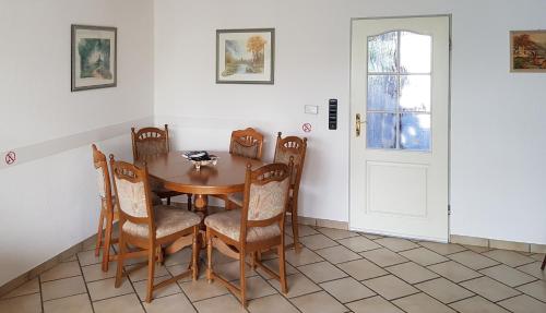 a dining room with a wooden table and chairs at Ferienhaus "Auberge Jolie" in Aachen