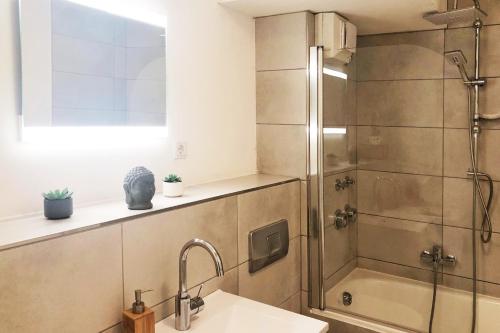 une salle de bain avec douche et lavabo dans l'établissement Gemütliches Apartment mit Balkon und Tiefgaragenstellplatz, à Wuppertal