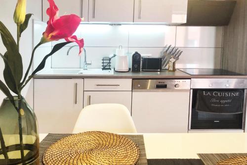 une cuisine avec un vase avec une fleur rouge sur une table dans l'établissement Gemütliches Apartment mit Balkon und Tiefgaragenstellplatz, à Wuppertal