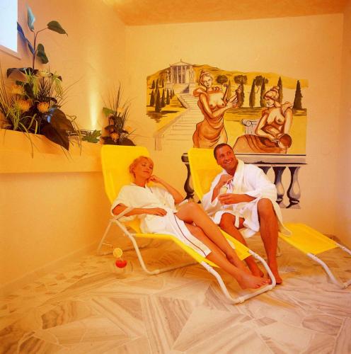 a man and woman sitting in lawn chairs in a room at Hotel Lisa in Flachau