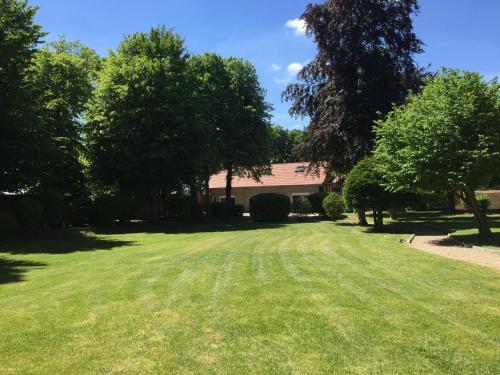 a large yard with trees and a building at Au domaine des roches in Saint-Pierre-sur-Dives