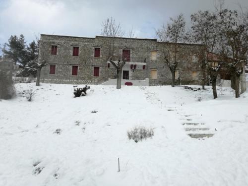 a building in a field with snow in front of it at The Magic Mountain in Tsapournia