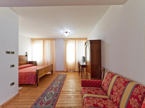 sala de estar con cama y sofá en Villa Butussi - L'ospitalità del Vino, en Corno di Rosazzo