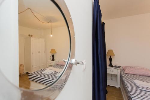 espejo reflejo de un dormitorio con 2 camas en Captain's apartment, en Račišće