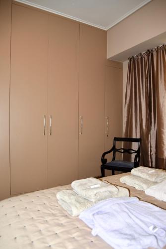 a bedroom with two beds and a chair at Amazing Apartment in Athens