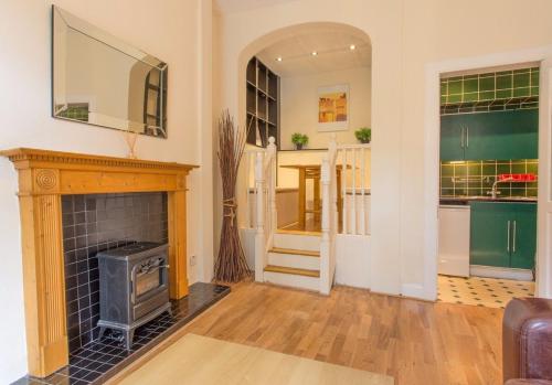 uma sala de estar com lareira e uma cozinha em The Broughton Road Residence em Edimburgo
