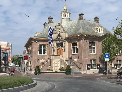 a large brick building with a flag in front of it at Appartement 't Loft in Zandvoort